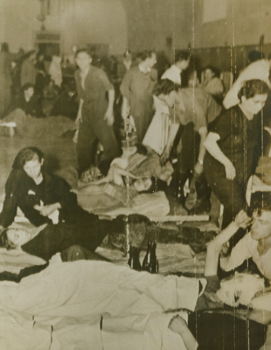 Injured Lie on the Floor, 10/3/1943. Naples, Italy—Prior to the entry of the allied forces into Naples, the Italian city’s hospitals were crowded far beyond their capacity. Here, those seriously injured as a result of the battle for their city, lie on the floor of the over-taxed hospital for incurables in Naples. Relatives and friends attend the patients, assist the overworked hospital staff. Credit: Photo by Charles Seawood, ACME photographer for War Pool, via U.S. Army Signal Corps radiotelephoto, from ACME.;