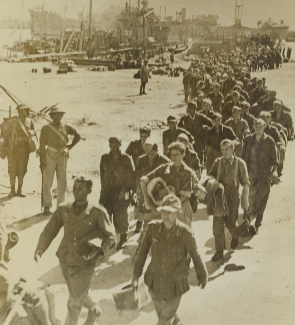 Captured by Americans in Italy, 10/4/1943. This photo, flashed to the U.S. by radiotelephoto today, shows a long line of Germans, captured by American troops in an Italian seacoast town, as they march off of lighters on their way to prison stockades “somewhere in Italy.” Secretary of the Navy Frank Knox, who was in Italy at the time, watched these prisoners march by. Credit: U.S. SIGNAL CORPS RADIOTELEPHOTO.;