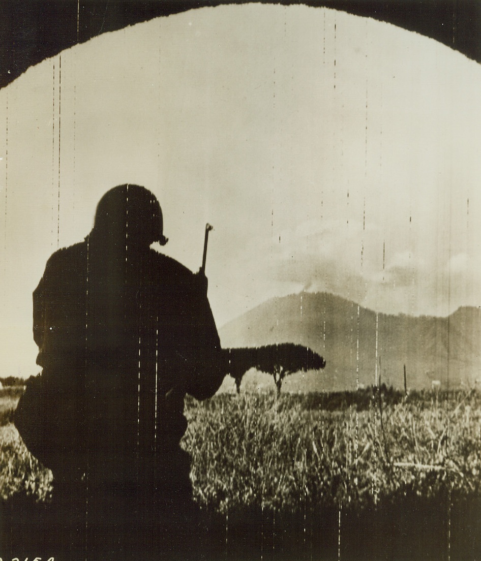 Yank Looks Toward Vesuvius, 10/3/1943. ITALY—Silhouetted in an ancient archway, among the ruins of Pompeii, an American soldier looks toward Mt. Vesuvius. Not far from his observation post, the famous old volcano spouts its eternal smoke. Credit: Photo by Charles Corte, ACME War Pool Photographer, via U.S. SIGNAL CORPS RADIOTELEPHOTO, FROM ACME.;