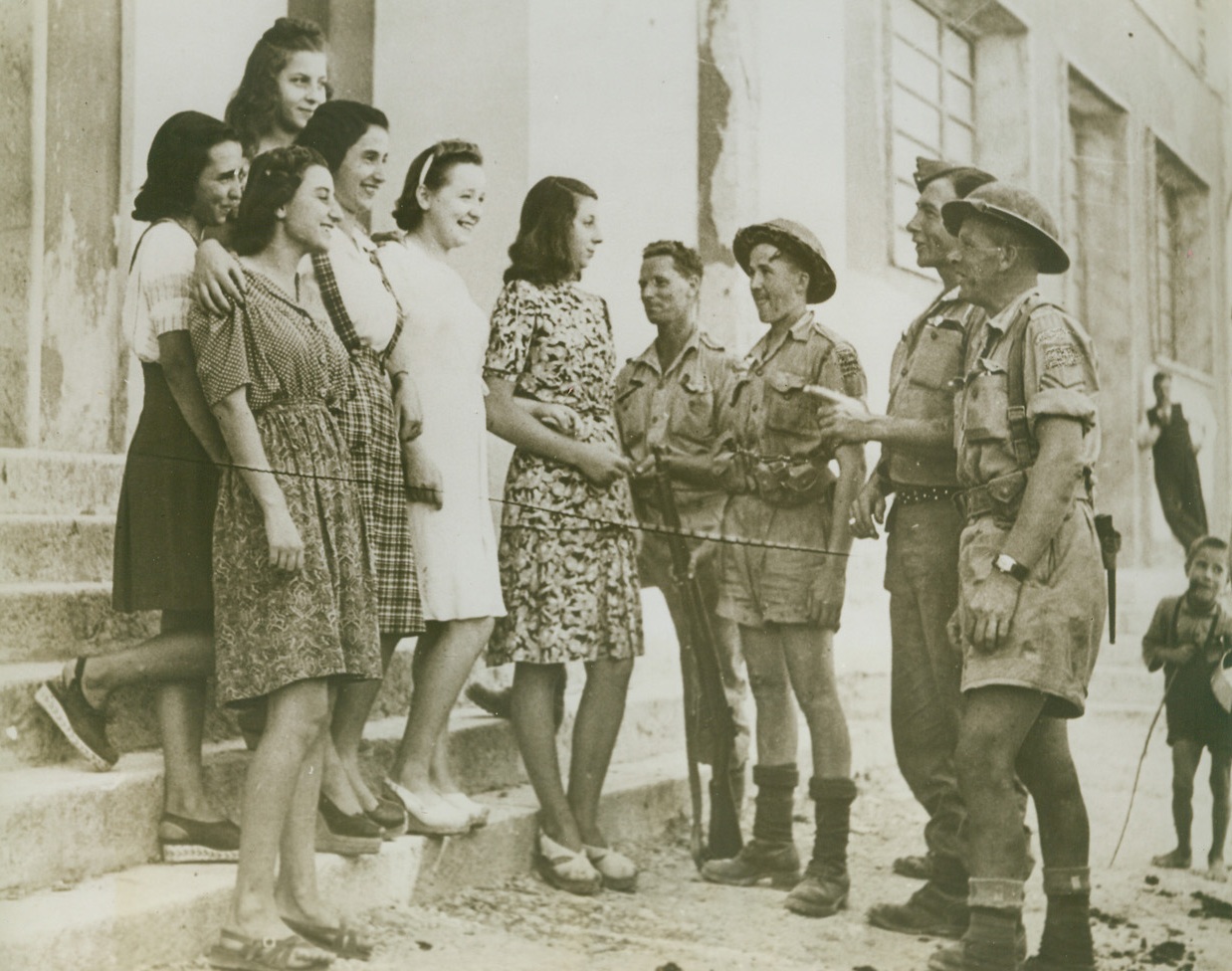 CANADIANS MEET SENORINAS, 10/29/1943. ITALY—Senorinas of the Italian town of Avigliano shine up to a Canadian street patrol. Canadians, left to right, are Pte. W. B. Campbell, Rolla, B.C.; Pte. C. E. White and Cpl. J. M. Frew, both of Edmonton. Fourth man is unidentified. Credit: Acme;