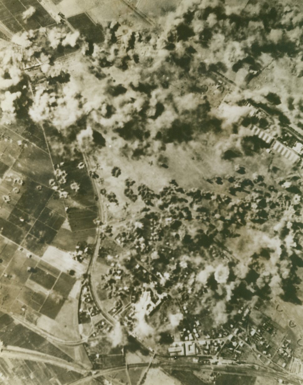 BOMBING AIRFIELD NEAR ROME, 10/2/1943. A surprise attack on Ciampino airfield, south of Rome, by U.S. Army Flying Fortresses of the Northwest African Air Force, caught a large number of Nazi aircraft on the field, and destroyed many of them. Here bomb bursts from the Army raiders cover the airfield. Credit: Army Air Forces photo from Acme;