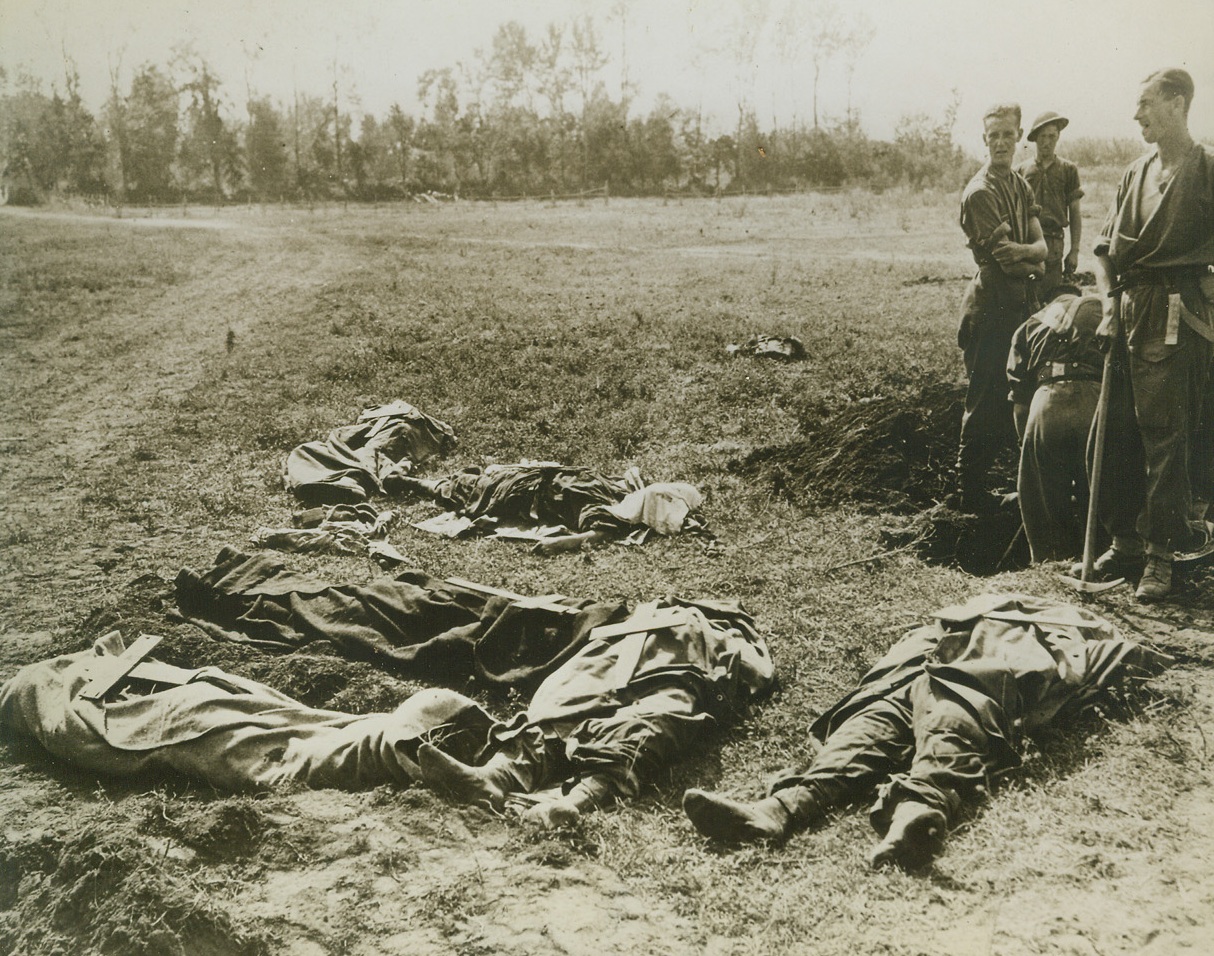 SALERNO IS THEIRS!, 10/9/1943. SALERNO, ITALY—There is a corner of this Italian field that is forever England or America—the final home of these fighting men who battled for Salerno and paid dearly for their prize. Stretched out in formless anonymity, with crude crosses placed upon their bodies, these war dead are buried by their comrades. Credit: Official U.S. Navy photo from Acme;