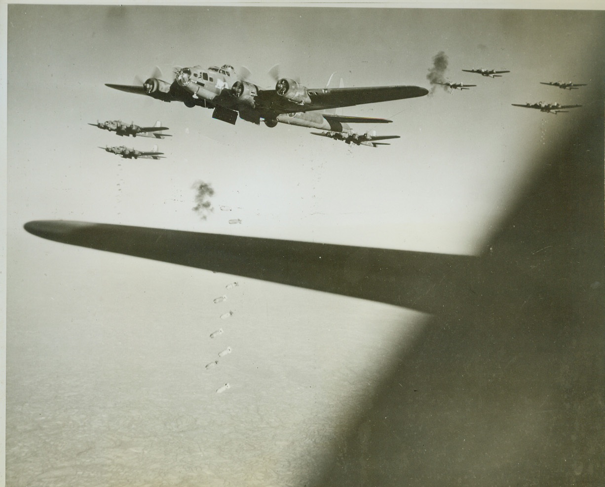 Yank Bombers Raid Nazi Fighter Base, 10/22/1943. GERMANY -- Flak bursts above and below the Fortress in foreground, sending shrapnel flying through the sky, as Forts of the U.S. Eighth Air Force Bomber Command raid a Nazi fighter base. The cry, "Bombs Away!" rings through each plane as tons of high explosives are released over the target. Credit (U.S. Army Air Forces Photo via OWI - ACME);