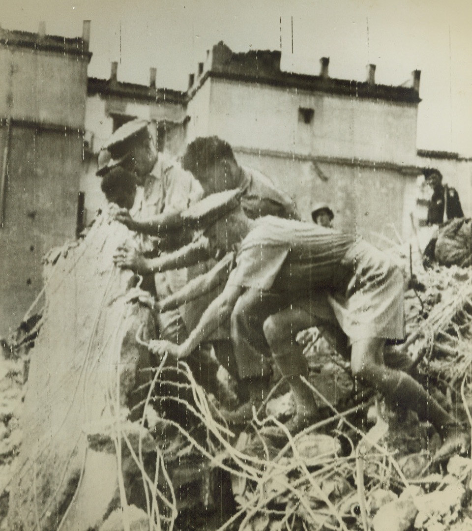 Searching for Dead or Wounded, 10/16/1943. NAPLES – British and American soldiers lift a portion of a cement floor in a search for possible dead in a U.S.-occupied barracks that was demolished by a time bomb left by retreating Germans. Naples post office was also shattered by such a time bomb. Credit – WP- (ACME Photo Via Signal Corps Radiotelephoto);