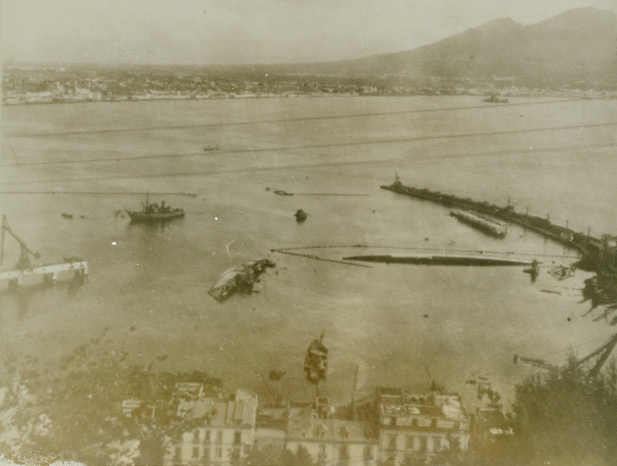 Bay of Naples Graveyard for Axis Ships, 10/6/1943. Sunken enemy ships lie in the harbor at Castel-Lammare, Italy, at the southern end of the Bay of Naples. This port had been used by Nazis for shipping and supplies to their troops in Sicily and North Africa, since the start of Allied campaigns.Credit (RAF Photo thru OWI from ACME);