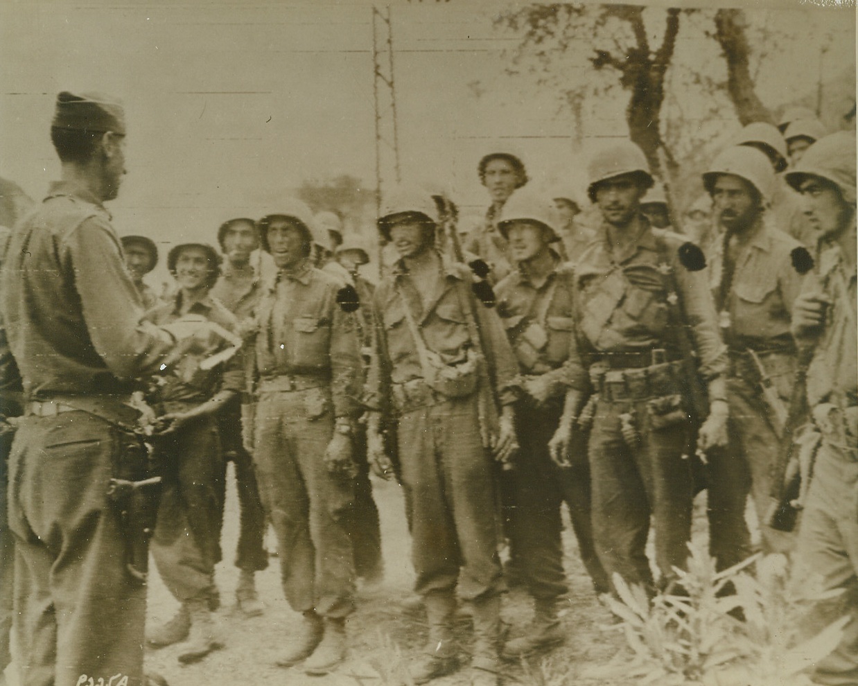 Congratulations from the Chief, 10/6/1943. Lt. Gen. Mark W. Clark, (far left), commander of the 5th Army, congratulates “his boys” after the American Infantrymen along with British forces, had been victorious in the Salerno area. This photo was flashed to the U.S. by Radiotelephoto. Today, the 5th Army has cracked Nazi lines along the Volturno River above Naples.Credit Line (U.S. Signal Corps Radiotelephoto from ACME);