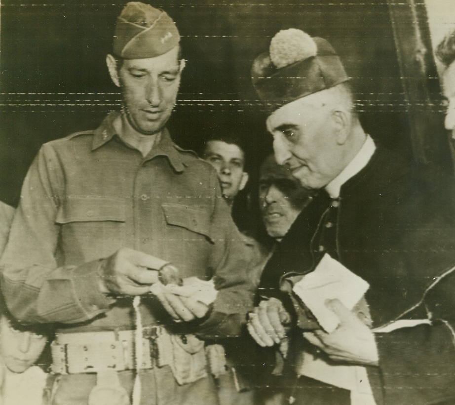 A souvenir for General Clark, 10/4/1943. ITALY – Lt. Gen. Mark W. Clark, commander of the 5th Army, admired a carved carnelian stone presented to him by Msgr. Francesco Guazzo (right), in appreciation for a gift of money raised by U.S. troops to repair his monastery at Cappaccio, which had been used by Germans as an observation post and damaged by artillery fire. Credit Line (U.S. Signal Corps Radiotelephoto from ACME);