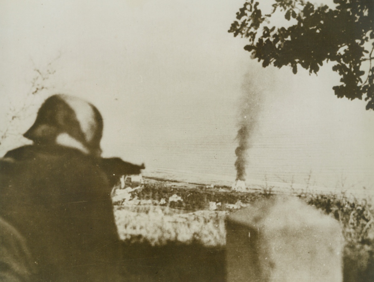 BIG JOB ON HIS HANDS, 10/24/1943. ITALY—A Nazi soldier, defending the southern coastline of Italy against Anglo-American invasion, fires at the crew members of an Allied tank who abandon their vehicle which was blasted by anti-tank shells. This caption accompanied the photo from Lisbon. Credit: Acme;