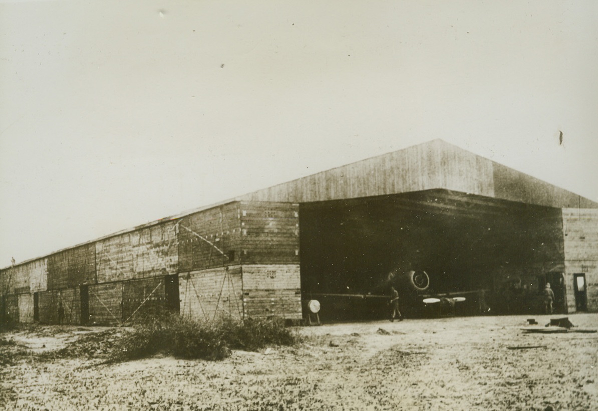 New Use for Old Crates, 10/6/1943. Sind Desert, India – Royal Air Force crews, stationed in India, where wood is at a premium, have found good use for crates in which fighter planes and plane parts are shipped. The crates are turned into bungalows, workshops and other necessary buildings. Sixty crates were used to build this hanger at an RAF Assembly Unit in the Sind Desert. Credit: ACME;