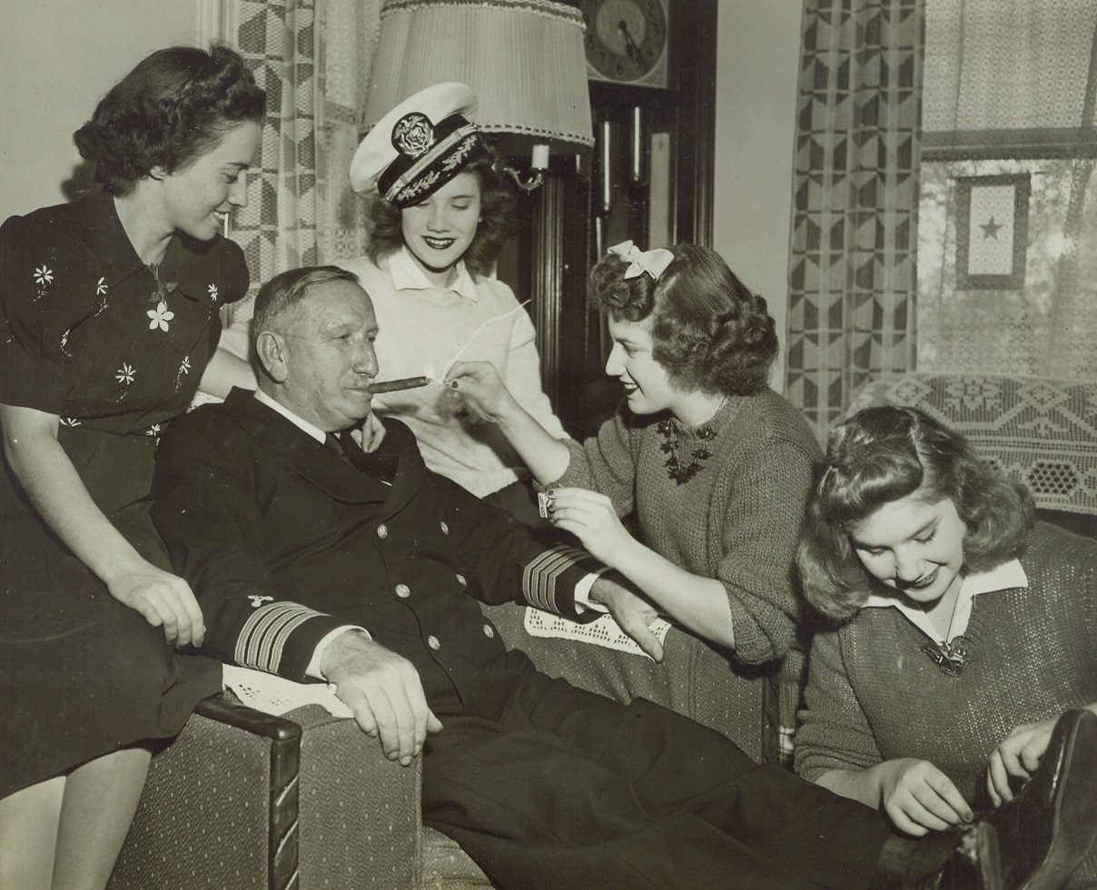 Wounded Hero of Three Wars Gets “The Works”, 10/16/1943. Park Ridge, Ill.—Capt. Charles Danielson, 68, receives the best of attention from his four daughters (left to right) Alice, Lorraine, Gloria, and Sylvia, when he arrived at the family home in Park Ridge, to recover from wounds received in landing operations at Salerno, Italy. The vet, formerly chief engineer on a Liberty ship, has been given the rank of captain. Credit: ACME.;