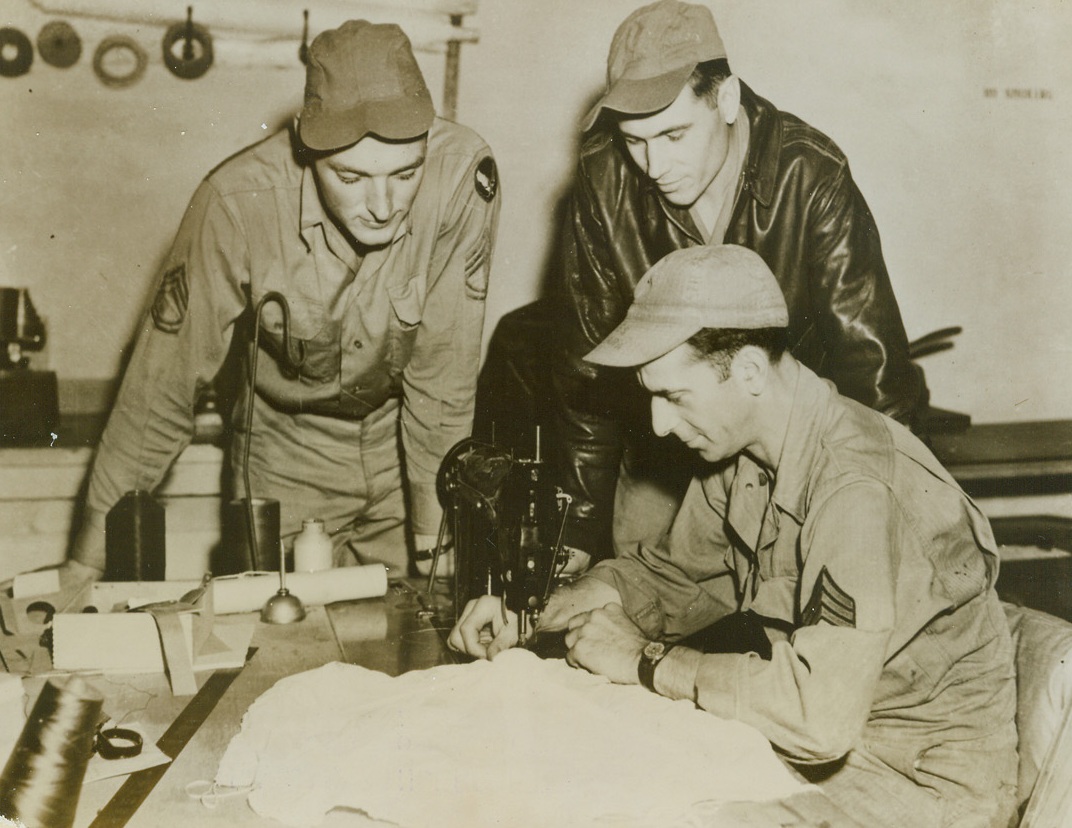 AIRMEN’S KINDERGARTEN, 10/7/1943. ENGLAND—Eager young officers of the Flying Fortress “Lucky Strike” talk over their latest mission after returning to their base, the “Kindergarten Station” in England. The base was named because none of its officers are more than 30 years of age. Left to right: Lieutenants Norman L. Wider, pilot, of Richmond Hills, N.Y.; Juan J. Porvencio, co-pilot, El Paso, Texas; and Douglas Baker, bombardier, Gloverville, N.Y. Credit Line (ACME);