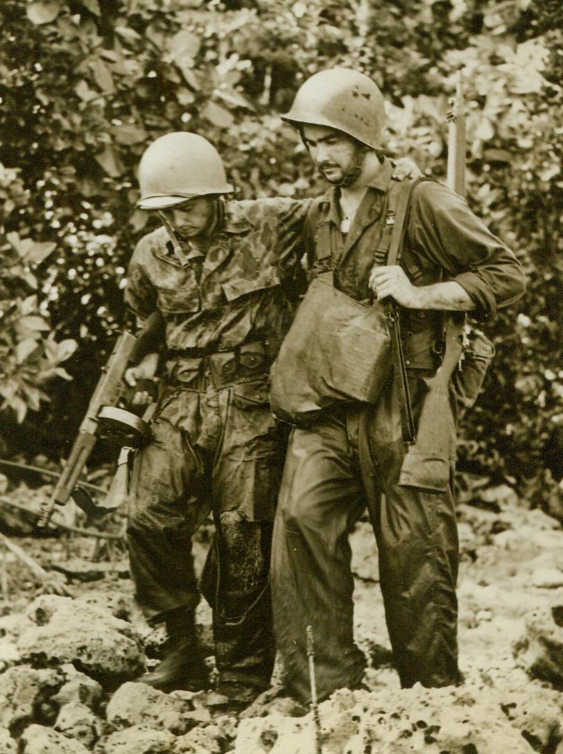 Wounded, They Help Each Other, 10/13/1943. New Georgia Island—In the best tradition of the service, two wounded American infantrymen help each other out of the dense jungles of New Georgia. Heading for the beach, they limp toward a Higgins Boat that evacuated them to a safer area. 10/13/43 (ACME);