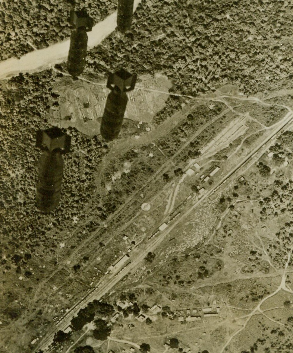 Blasting Japs' Burma Supply Line, 10/28/1943. This photo, just released in the United States, shows bombs (left), from U.S. 10th Air Force medium bombers dropping toward the important railroad junction at Naba, Burma, through which passes much of the oil from the rich Burma fields to supply Japanese invasion forces. This recent raid is part of the growing air offensive against Jap supply lines and installations in Burma 10/28/43 (U.S. Army Air Forces Photo From ACME);