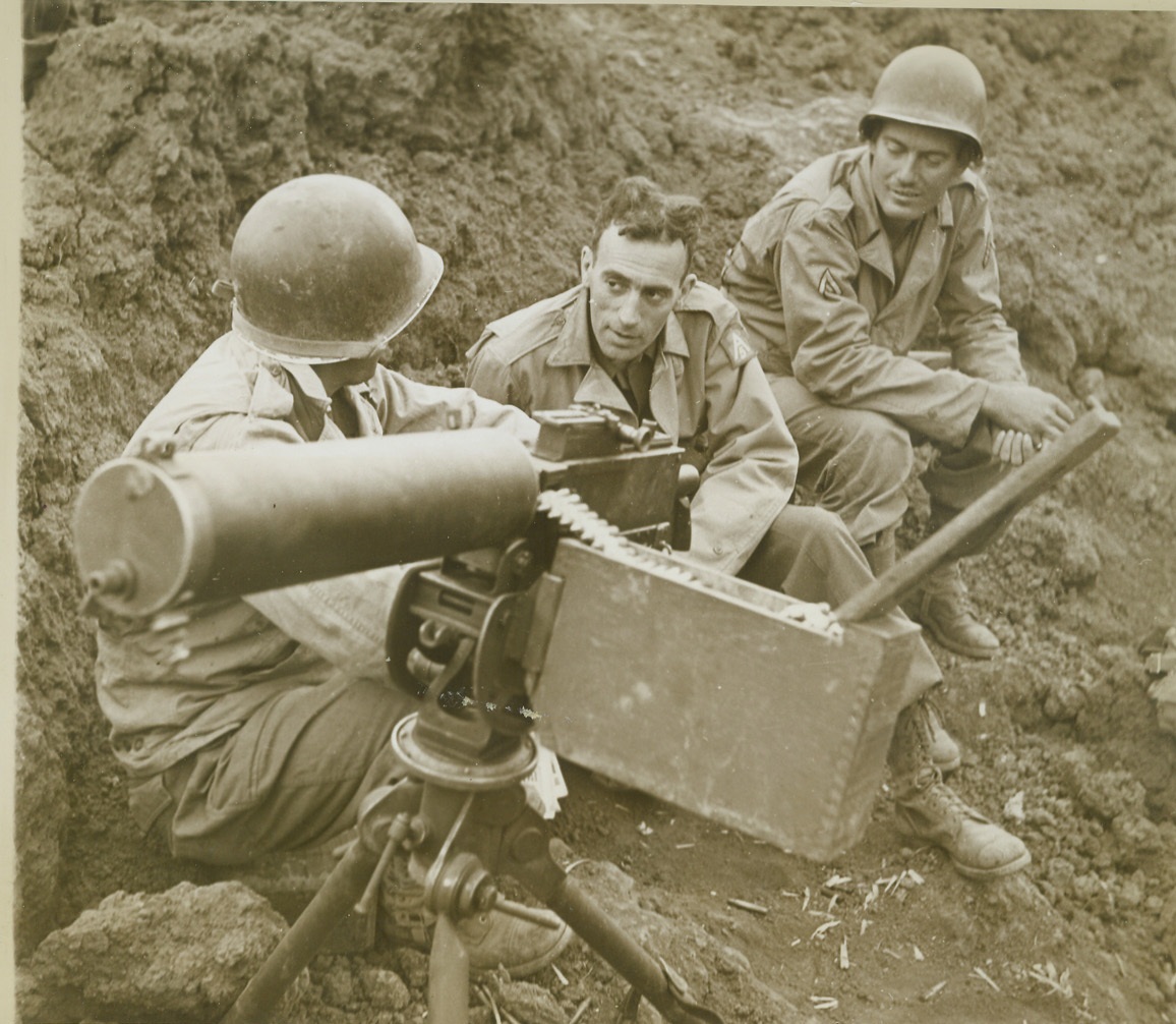 Frontline Interview, 11/23/1943. With the 5th Army in Italy – Cy Korman, (center) Chicago Tribune war correspondent, interviews members of a frontline machine gun post, located in a ten-foot-deep shell crater along the Italian Front. At right is Pfc. Raymond Kubilek, of Vernon, Texas. At left, is Pvt. Frederick Stewart, Hictonville, Ind.  Credit: (ACME Photo by Bert Brandt for the War Picture Pool);
