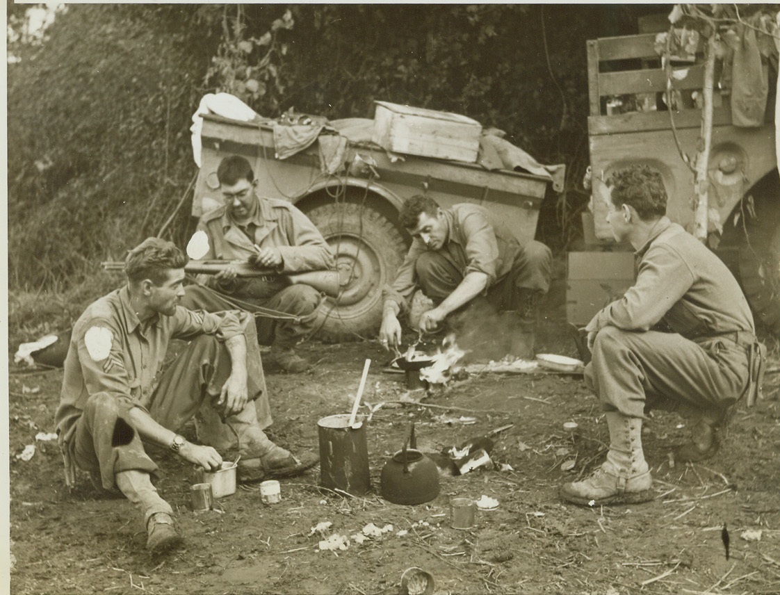 A Snack at the Front., 11/8/1943. PIETRAVAIRANO, ITALY - It may not be eight-course dinner at the Ritz, but this snack cooked over a campfire near the front, tastes just as good to these U.S. Infantrymen. Left to right, are: Pfc. Stanley Machinski, of Toledo, Ohio; Pvt. Alvin Kennedy, Harrisonburg, VA., who uses part of his lunch hour to clean his gun; Pvt. Harvey Craig, Stigler, Ohio; and Corp. Gerald Gould, of Seattle, Wash. (Passed by Censors). Credit: ACME photo by Bert Brandt for the War Picture Pool;