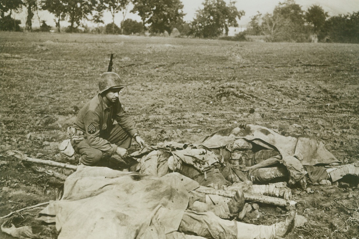 American Dead in Italy, 11/9/1943. CASERTA, ITALY – Sgt. R. Strebe, of Washington state, checks the identification of the bodies of these American soldiers, who were killed in the fighting on the outskirts of Caserta.;