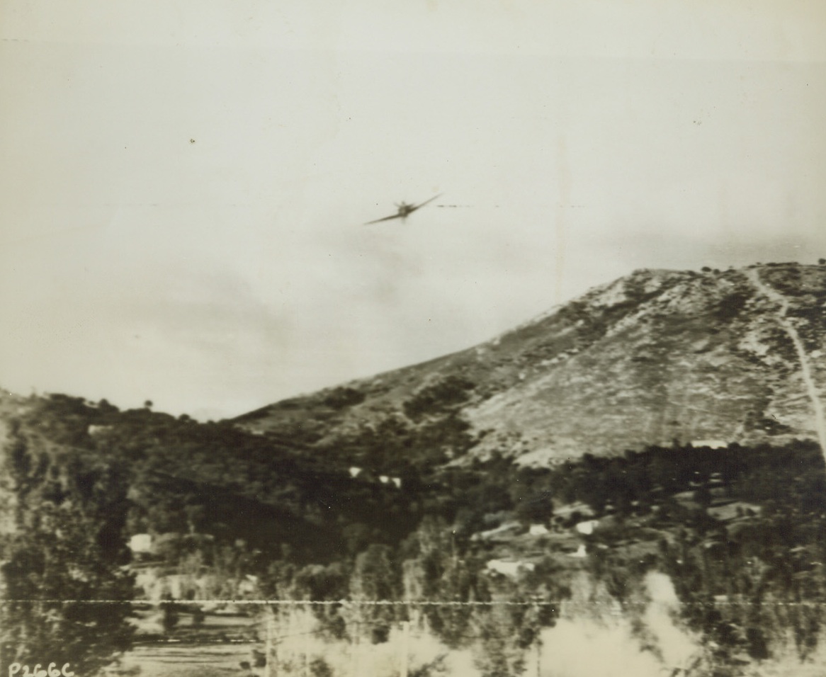 Making it Tough for the Yanks, 11/5/1943. ITALY—A Nazi plane flies low and at a terrific speed to strafe a road in Italy that is choked with U.S. Army vehicles. Machine guns blazing, the German aircraft peppers the American equipment with bullets, smoke and dust arising as the shells hit. Credit: ACME Photo via U.S. ARMY SIGNAL CORPS RADIOTELEPHOTO.;