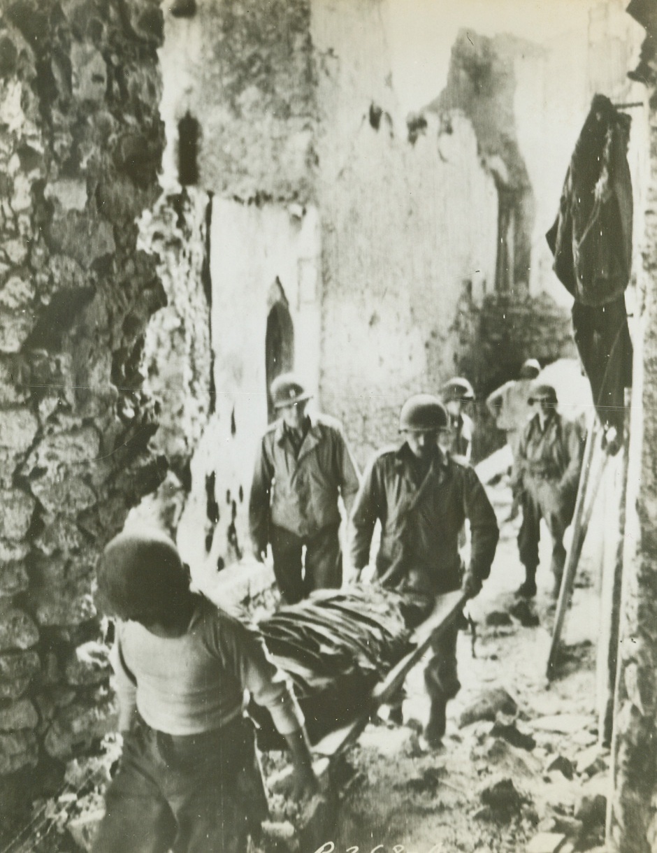 He Died for His Country, 11/8/1943. PIETRAVAIRANO, ITALY—An American soldier, who fought and died in this Italian city, is carried to a burial place through the rubble-strewn streets by two of his buddies. Today, it was announced that the Allied 5th Army was only 9 miles from the important port of Gaeta, where Germans are feverishly destroying harbor installations in preparation to abandoning it. Credit: U.S. SIGNAL CORPS RADIOTELEPHOTO from ACME.;