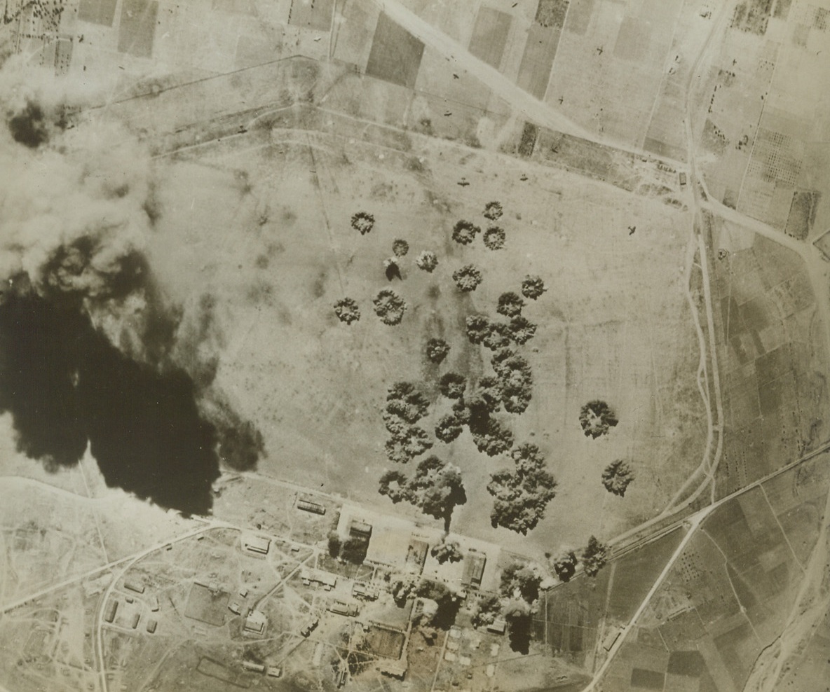 YANKS BOMB NAZI AIRFIELD IN GREECE, 11/11/1943. Bombs from Flying fortresses of the Northwest African Air Forces explode neatly within the target area on the Nazi-held airfield at Sedes, Greece, near Salonika, during a recent raid. Note extremely wide dispersal of aircraft, (in area from top to bottom, left in photo). Despite the fact that Greece has not been in the headlines, Allied air forces have bombed enemy-held installations on a number of occasions.Credit: U.S. Army Air Forces photo from Acme; Bombs from Flying fortresses of the Northwest African Air Forces explode neatly within the target area on the Nazi-held airfield at Sedes, Greece, near Salonika, during a recent raid. Note extremely wide dispersal of aircraft, (in area from top to bottom, left in photo). Despite the fact that Greece has not been in the headlines, Allied air forces have bombed enemy-held installations on a number of occasions.Credit: U.S. Army Air Forces photo from Acme;