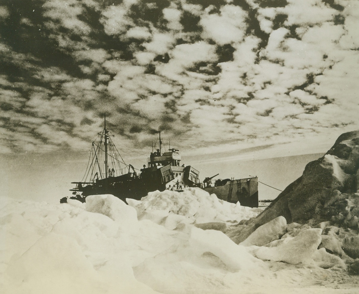 German Weather Base Destroyed, 11/9/1943. Secretary of the Navy Frank Knox today revealed that a powerful German radio and weather base on an island off the coast of Greenland, had been destroyed by U.S. Forces and two prisoners taken. This is the second time in recent months such a base has been taken. Here, a Coast Guard Cutter waits offshore as its landing force of Coast Guardsmen and soldiers advance on the base. A second cutter taking part in the combined operations became jammed in the ice and was trapped for a month.Credit: (U.S. Coast Guard Photo from ACME);