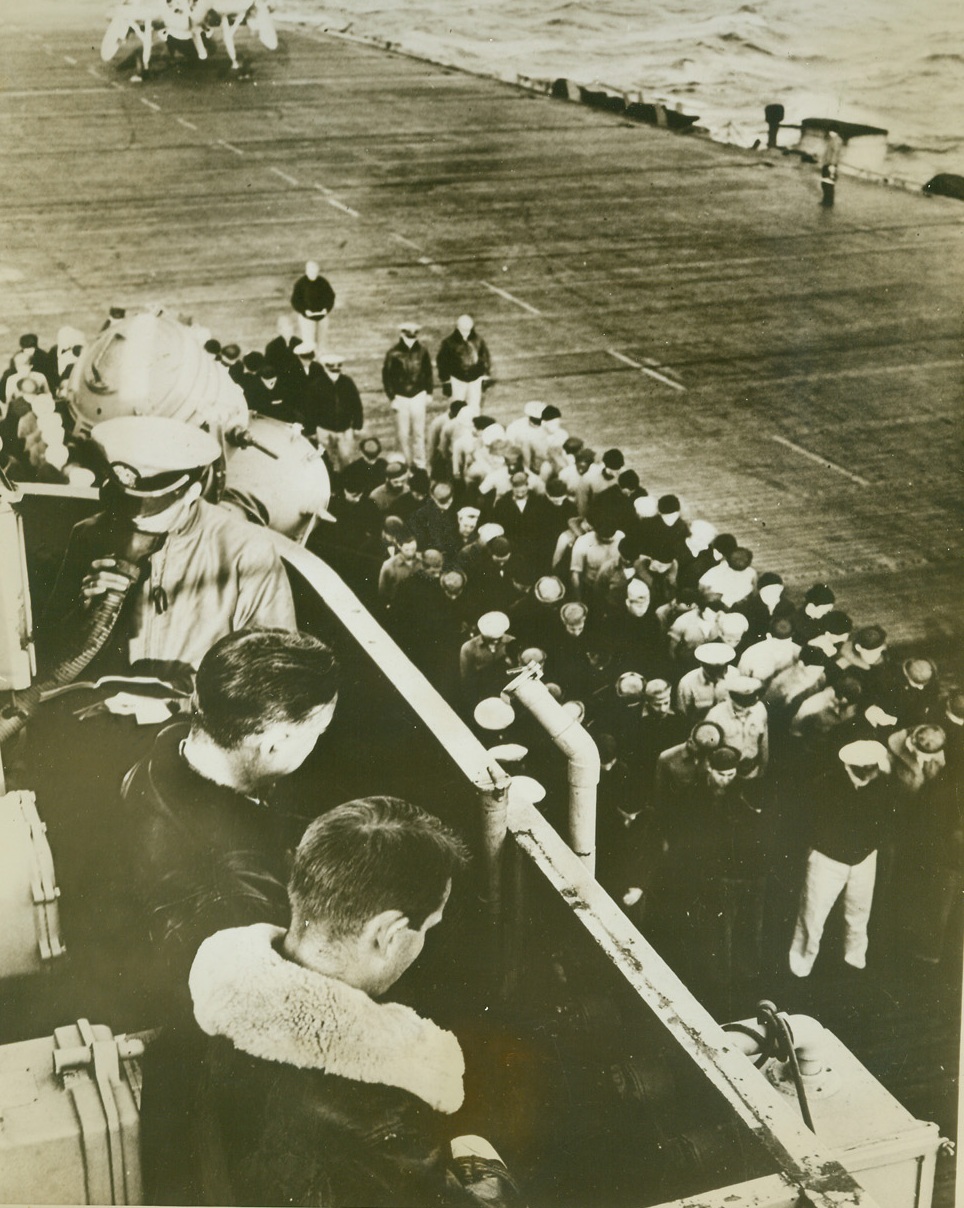 ON THE ATLANTIC, 11/16/1943. With heads bowed, …survived the epic battles between the old four-stacker destroyer USS Borie and two Nazi U-boats attend memorial rites for the 27 officers and men lost in the double victory. The services were held aboard the escort carrier USS Card, whose torpedo planes gave the “coup de grace” to the Borie when she was found to be beyond salvage. Here, on the Card’s bridge, during the services are: Chaplain S.W. Bell, (background), reading the service through the ship’s loud speaker system; Capt. Arnold J. Isbell, (center), commanding officer of the Card; and Lt. Comdr. (then Lt.) Charles H. Hutchins, commanding officer of the Borie.Credit Line (U.S. Navy Photo from ACME);