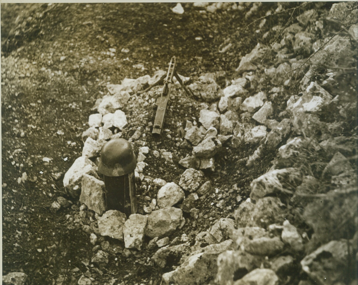 He Fell by the Wayside, 11/18/1943. SOMEWHERE IN ITALY -- Killed while attempting to machine gun pack trains making their way over rocky Italian terrain, a German soldier lies where he fell, just below the path over which the pack trains travel. His helmet and his gun mark his rocky grave.  Credit: - WP - (Photo by Bert Brandt, ACME Correspondent for War Picture Pool);