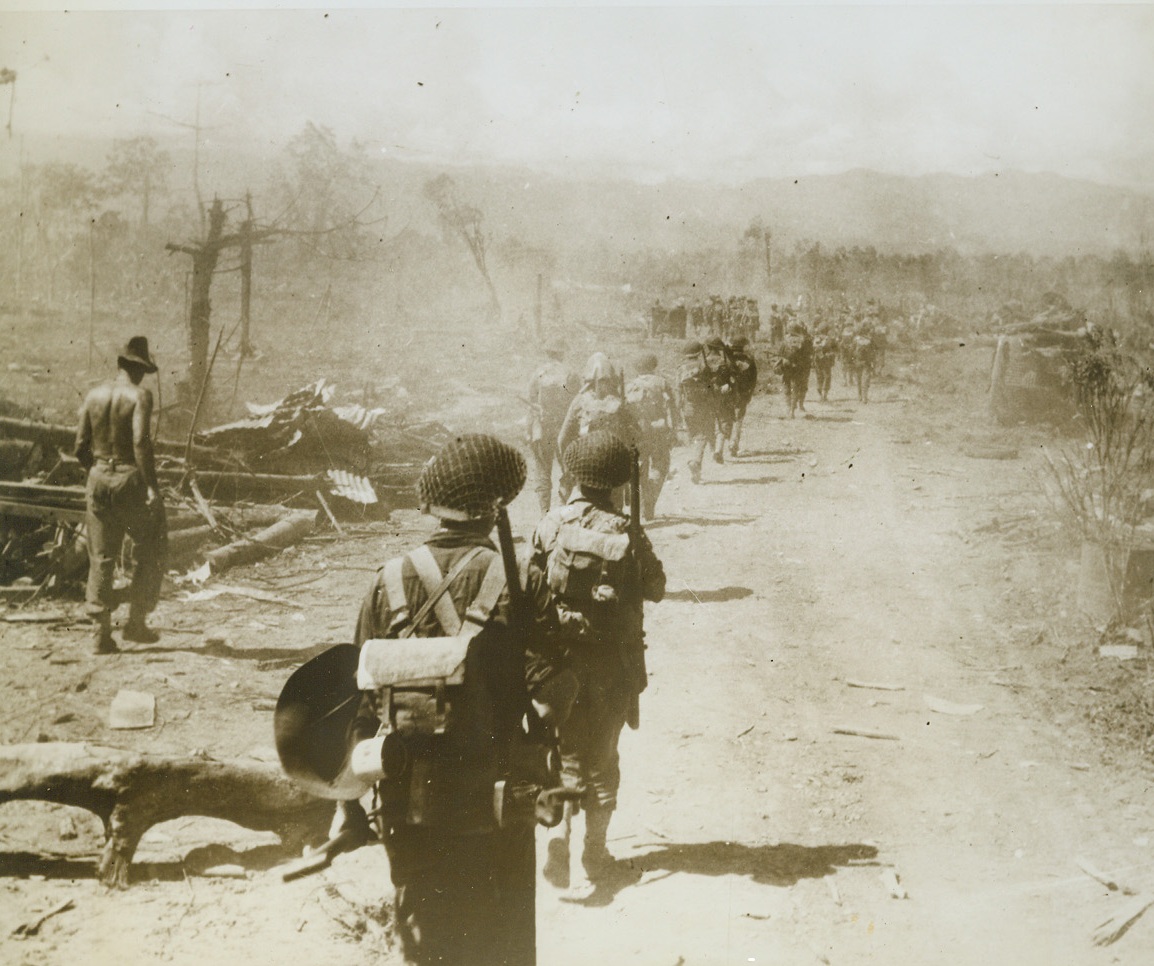 ANOTHER MILESTONE ON THE ROAD TO TOKYO, 11/3/1943. Devastation marks the road on either side of Allied troops as they marched into Lae, on Sept. 18th, 1943, shortly after the New Guinea outpost of the Nipponese was captured. “Hell on Earth” is the description of the attack on the Japs, before they gave up. Credit: Official U.S. Navy photo from Acme;