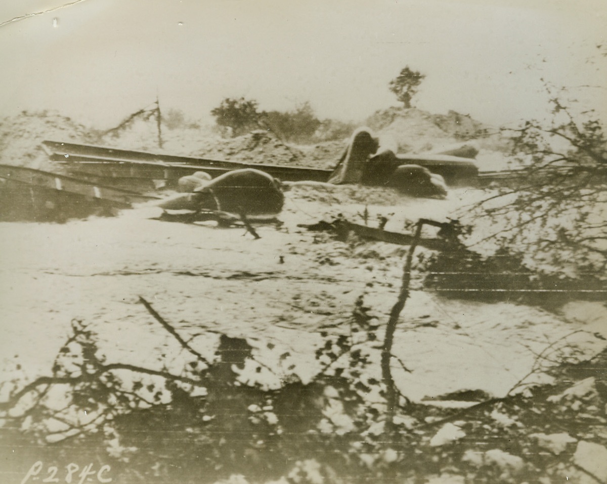 PONTOON BRIDGE WRECKED BY FLOODWATERS, 11/20/1943. ITALY—One of the reasons why the American advance in Italy has been slowed up is evidenced by the scene here showing how Volturno River floodwaters, brought about by heavy winds and rain, played havoc with a pontoon bridge thrown across the river just north of Venafri. Washed out by the flood waters, pontoons bounced about in the swirling stream. Credit Line (US Army Signal Corps Radiotelephoto from ACME);
