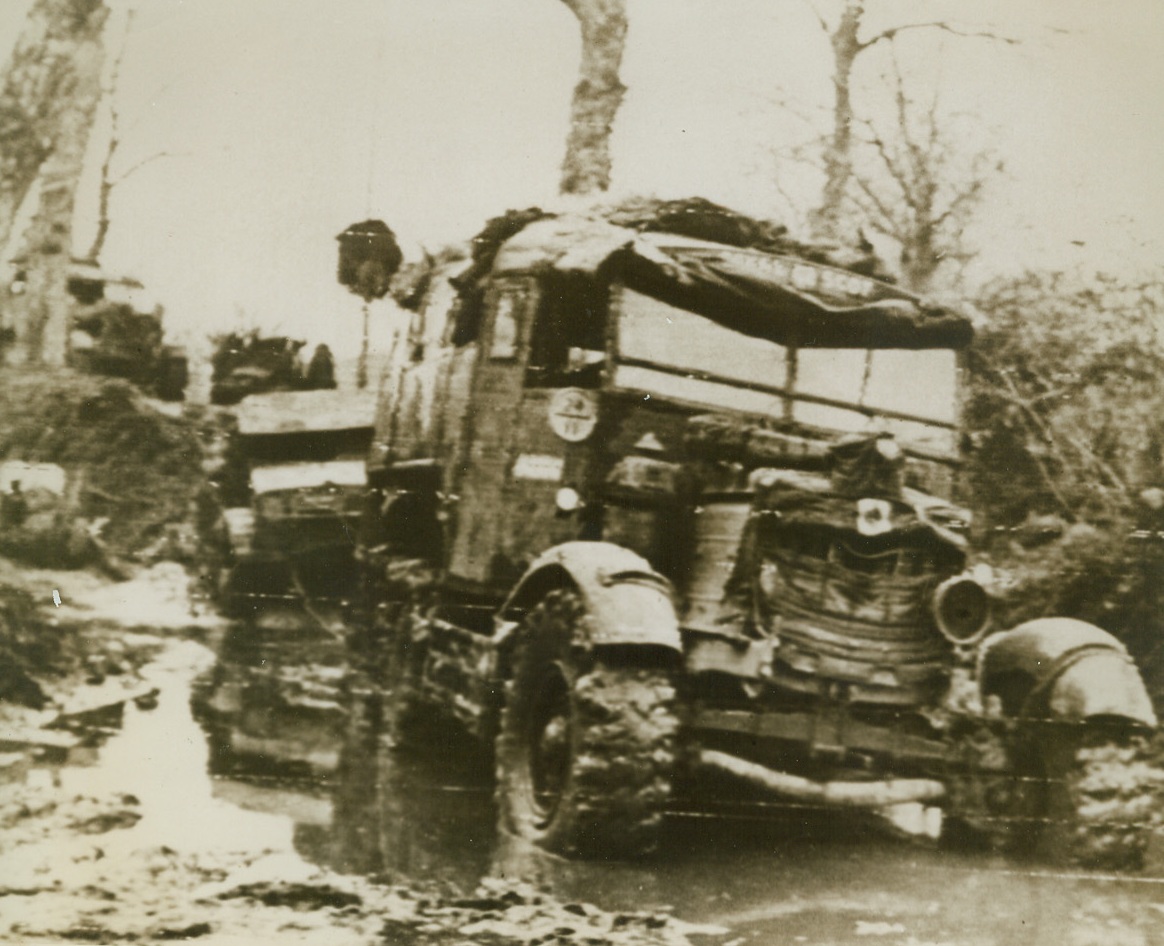 MUD SLOWS UP ADVANCE IN ITALY, 11/23/1943. ITALY—A big British vehicle tows a lighter car through deep mud holes in a sector on the Italian front. Steady rain has slowed up military operations. Credit (ACME Photo by Bert Brandt for the War Picture Pool via Army Radiotelephoto);