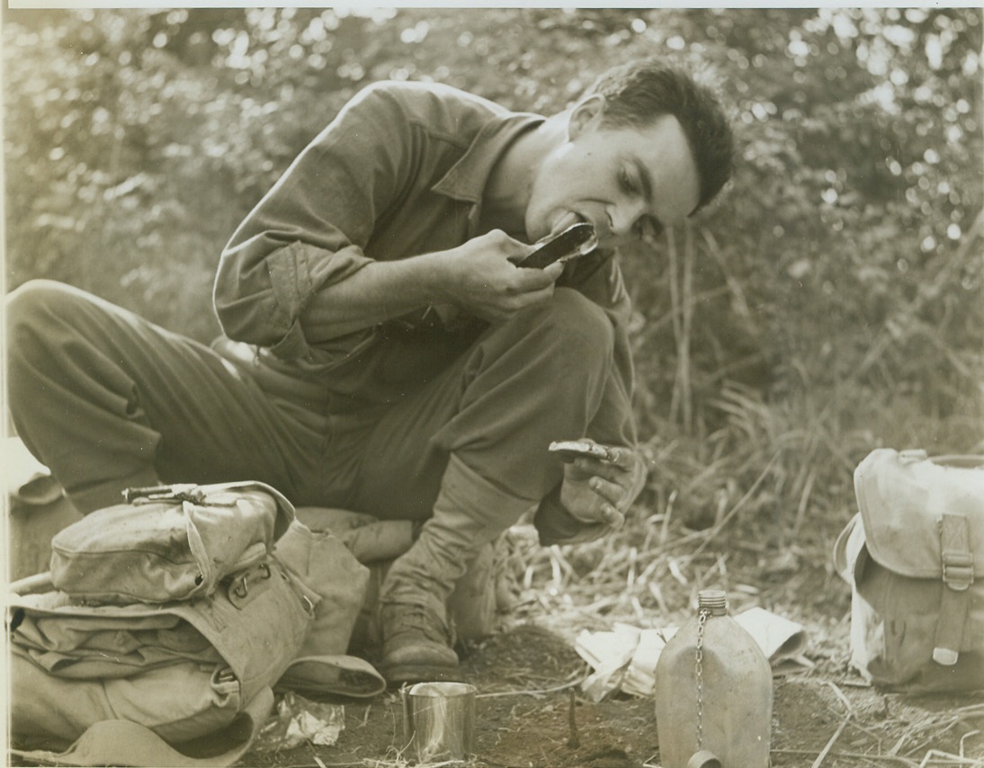 No Use Wasting Any, 11/8/1943. ITALY -- Pvt. Bill Duncan, Mason City, Ia., licks the top of a chocolate syrup can after pouring some of it over his crackers for a field-made dessert. He is a member of a U.S. Infantry regiment which made a half-hour stop for lunch near Pietravairano, Italy. The men prepare their meals from field rations as best they can. On many days the soldiers are not lucky enough to get peace and quiet for their noon-time meals. Credit: -- WP-- (ACME Photo by Bert Brandt, War Pool Photographer);