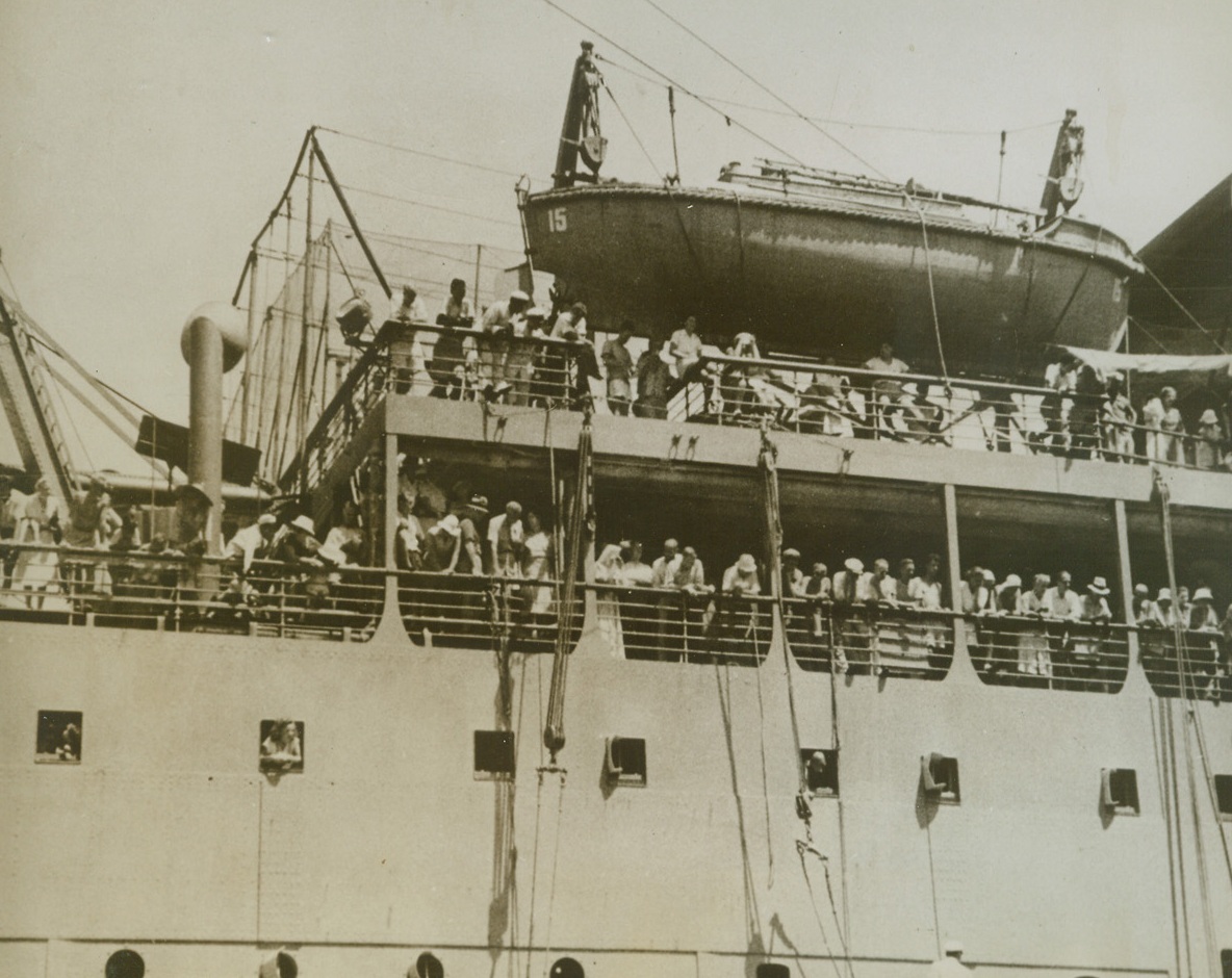 On Their Way to Freedom, 11/1/1943. Portuguese, India – The sight of Mormugoa, Portuguese India, represents the end of nightmarish confinement in Japan to these 1,500 allied internees arriving on the Jap exchange ship Teia Maru.  Among the exchange prisoners crowding the rails are 1,100 American Nationals.Credit Line (ACME);
