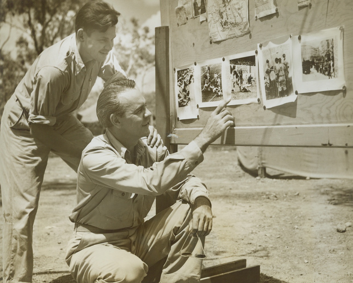 When Reconnaissance is a Pleasure, 11/22/1943. Australia – First Lieut. James J. Goetz, of Chicago, Ill., group photo interpreting officer (right), really puts in some expert opinions as he “interprets” world series and football telephoto pictures for Major Howard K. Williams, of Salt Lake City, Ground Executive Officer of an American B24 bombing group.  The pictures were received over the ACME telephoto machine, used by the Signal Corps in Australia. Credit line (ACME photo by Thomas L. Shafer, War Picture Pool correspondent);