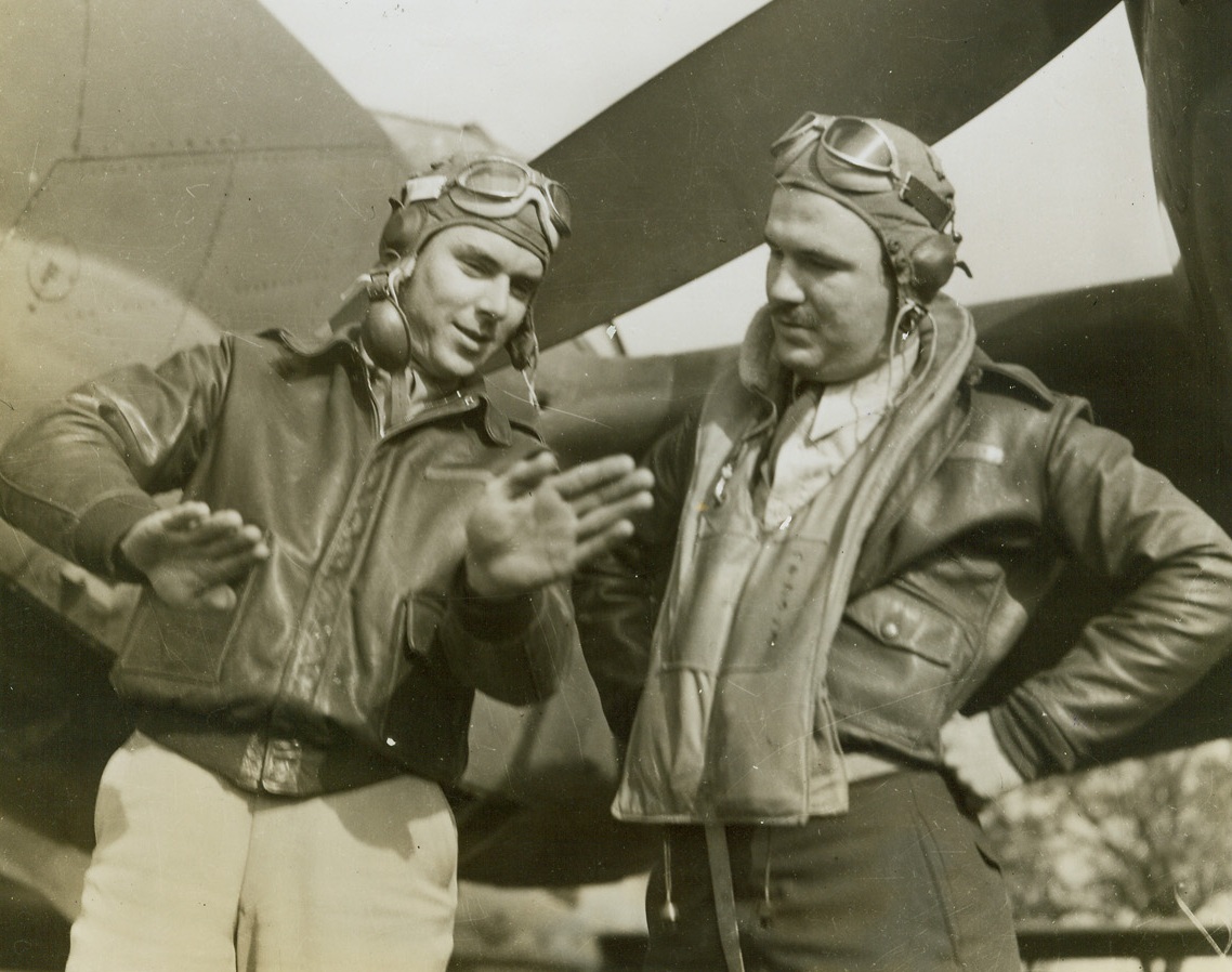 Here's How It Happened, 11/4/1943. England – At a U.S. P-38 Lockheed Lighting Fighter base “somewhere in England”, First Lt. Thomas F. Hetherington, (left), of San Antonio, Texas, shows First Lt. Richard T. Stovall, of Galena, Ill., how his P-38 and an enemy plane took part in a hot bit of action. Credit: Acme;