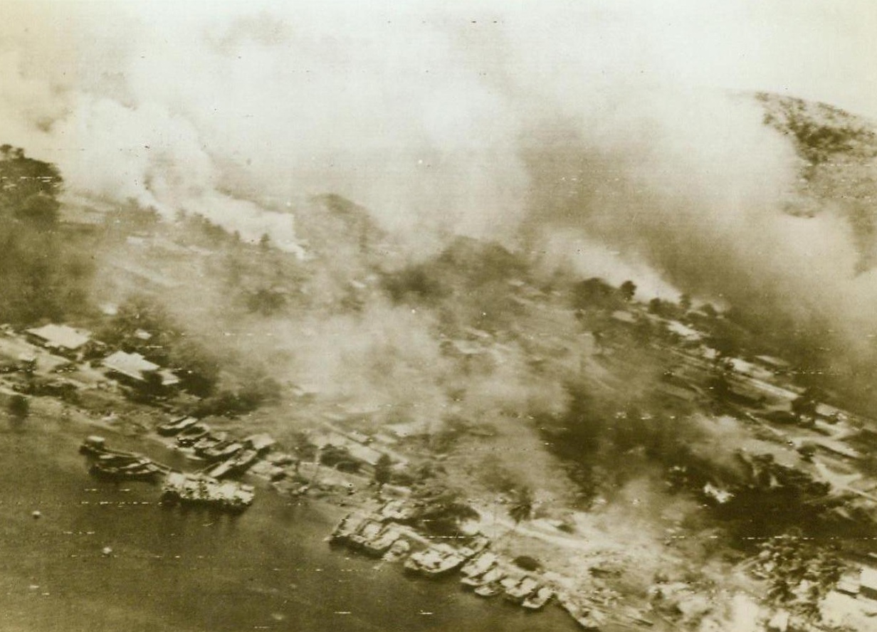 Yanks Blitz Rabaul Again, 11/8/1943. The waterfront section of Rabaul, powerful Jap base on New Britain, burns fiercely after a raid last Nov.2, by B-25 Mitchell Bombers under the command of Maj. Gen. George C. Kenney. Yank forces have hit again, and yet again at this base but the Nips are still able to concentrate large forces here. The larges group of Jap warships in many months, is now gathered at Rabaul, and a naval showdown with U.S. forces is shaping up rapidly. 11/8/43 (ACME);