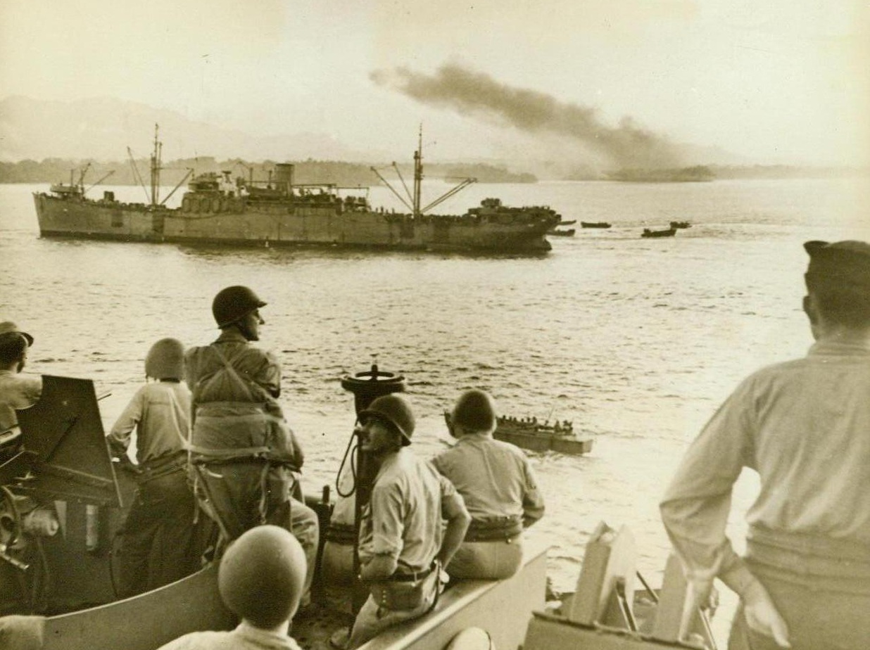 Headed For Bougainville, 11/15/1943. Bougainville -- Landing craft loaded with U.S. Marines, leave the sides of transports headed for the invasion of Bougainville. In the background (right), a smoke pall hangs over Torokina Beach, after our dive bombers had blasted Jap installations to shreds in preparation for the landing of Marines. This invasion has been called "the toughest of the whole Solomons Campaign." 11/15/43 (ACME);