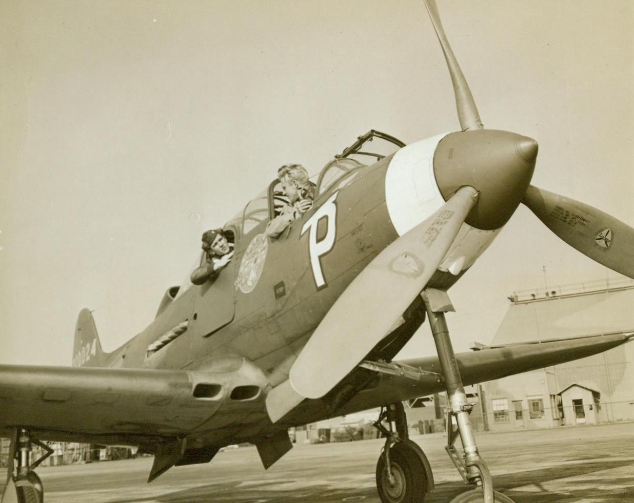 Aircobra Becomes "Hot" Trainer, 11/26/1943. Oakland, Calif. – The newest thing in racy Army trainers is the speedy  Bell Aircobra P-39 fighter, with a second cockpit cut in the ship’s nose so that both trainee and instructor can fly. In the front seat is Capt. Charles Tucker, who recently returned from China where he flew with the 14th Air Force. Lt. L.V. Andrews sits behind him 11/26/43 (ACME);
