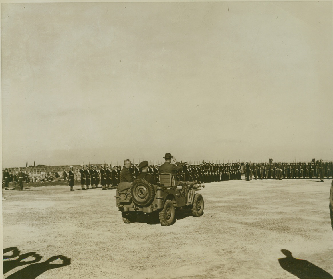 ROOSEVELT REVIEWS GUARD IN MALTA, 12/14/1943. MALTA – President Franklin D. Roosevelt, (seated in front), and Field Marshal Lord Gort, (seated in rear), Commander-In-Chief of Malta, as they rode along in a jeep to review a Guard of Honor, during the President’s recent visit to the Mediterranean Island. The Guard was made up of a RAF Unit, 50 British Marines, 50 Royal Navy men, and 100 Maltese troops. The jeep is one of three presented to the British by Gen. Dwight Eisenhower and the vehicle bears the name, “Husky” Credit: OWI Radiophoto from ACME;