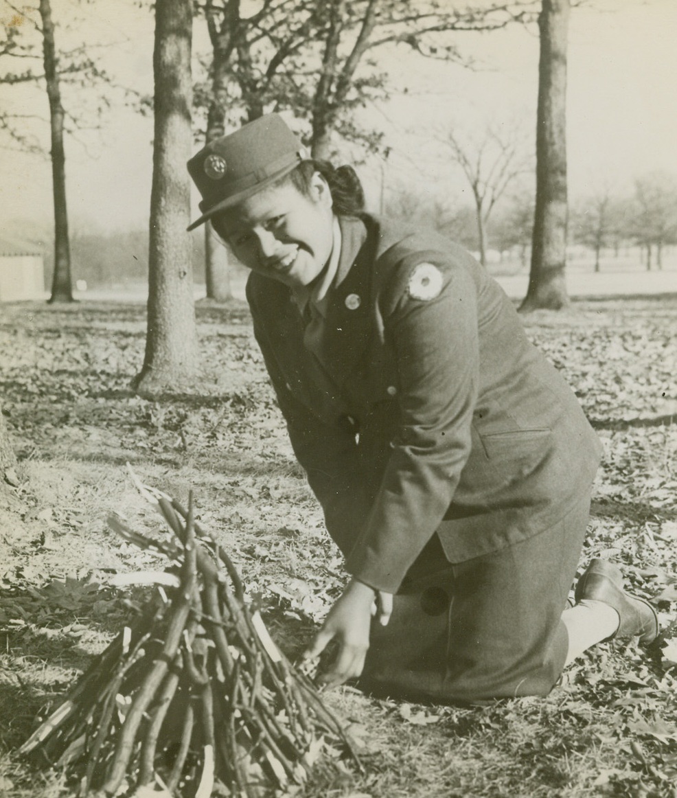 WITH FLINT AND STEEL, 12/3/1943. CAMP GRANT, ILL.—Kathryn N. Butler, Hudson, Wis., first Indian WAC to be stationed at Camp Grant, Ill., where she works in the hospital’s diet kitchen, demonstrates how a modern Indian starts a fire with flint and steel—by using a cigarette lighter.Credit: Signal Corps photo from Acme;