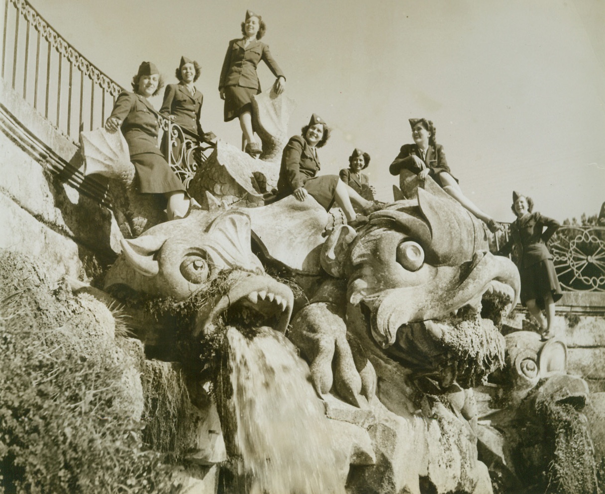 DECORATIVE TOUCH, 12/5/1943. ITALY—A vast improvement is effected in the weird statuary of the royal gardens of Caserta, italy, by seven sightseeing WACS who are (left to right) Pvt. Jeanne Zientek, of Buffalo, N.Y.; Pvt. Jerry Horne, Lucedale, Miss; Pvt. Betty Hoefler, of Buffalo, N.Y.; Pvt. Laura Howleson, of Pittsburgh, Pa.; Pvt. Zanaida Johnson, of New York City; Pvt. Rena Hicks, of Louisville, Ky., and Pvt. Ruby Hale, of Wharton, Tex.Credit: Acme photo by Bert Brandt, War Pool Correspondent;