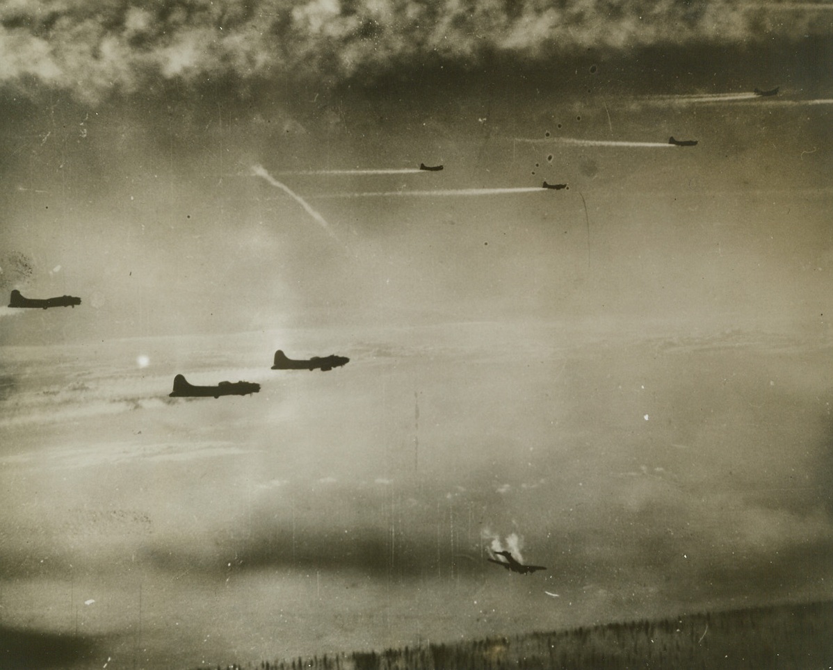 Death of a Flying Fortress, 12/28/1943. Smoke pouring from its motors and part of its tail assembly shot away, a flying fortress hurtles from a formation of the big bombers speeding towards Bremen, Germany. The rest of the U.S. 8th Army Air Force planes soar onward, for no help can be given the fallen eagle. Credit: U.S. Army Air Force photo from ACME.;