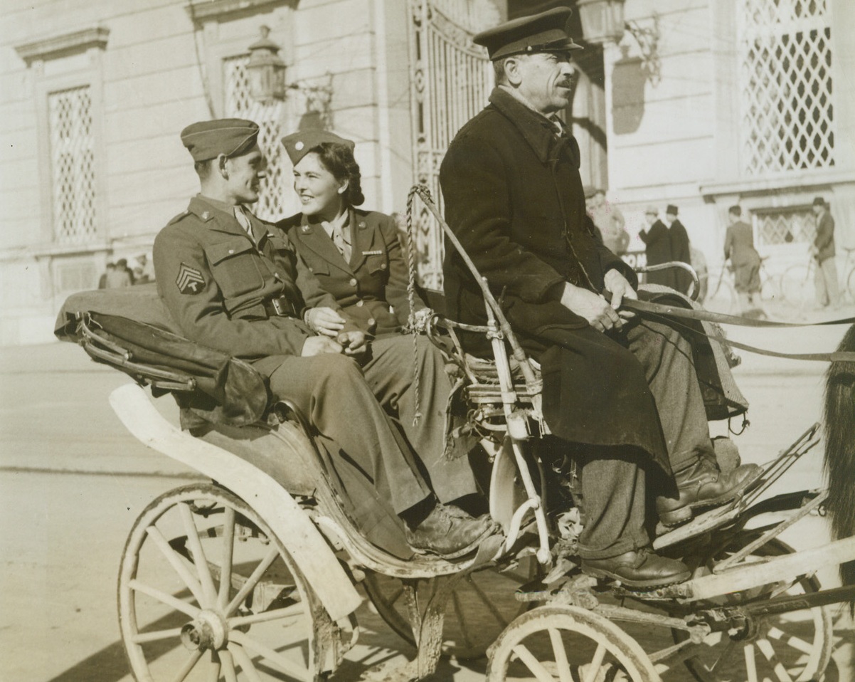 Gosh!, 12/15/1943. ITALY -- …is all that Sgt. Frank Friel, of Portland, Me., can say as pretty WAC Pvt. Rena Hicks, of Louisville, Ky., favors him as an escort for a drive in a picturesque carriage around Caserta, Italy. Credit (ACME Photo by Bert Brandt, War Pool Correspondent);