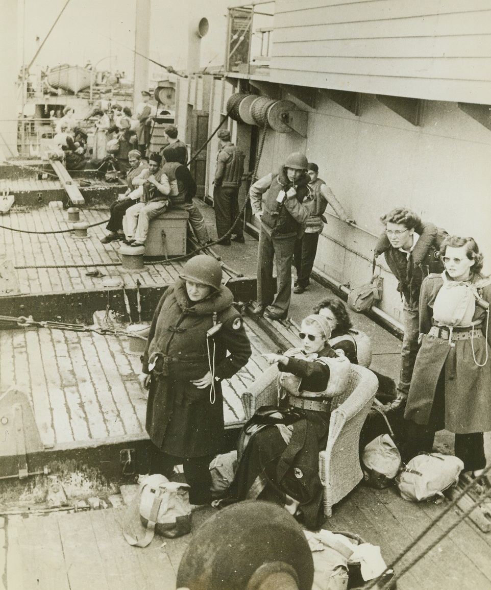 TENSE MOMENT ON SHIPBOARD, 12/28/1943. This photo, taken aboard a transport carrying U.S. troops and Red Cross girls to one of the battle fronts, was taken during a tense moment during an attack by an enemy submarine. The U-boat was sunk or driven off before it had a chance to do any damage.Credit: Red Cross Photo from Acme;