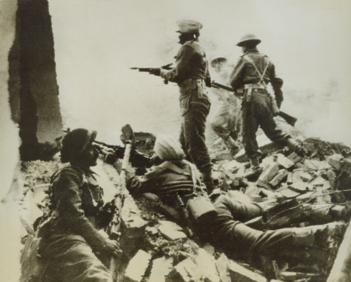 INDIAN TROOPS FIGHT WITH 8TH ARMY, 12/20/1943. ITALY—An Indian Bren gunner, (second from left), gives covering fire, as Indian and British troops of the 8th Army advance on the Italian Front. At the time this photo was taken, the town and this emplacement were under heavy German mortar fire. This photo flashed to New York by radio from Algiers, today.Credit: OWI Radiophoto from Acme;
