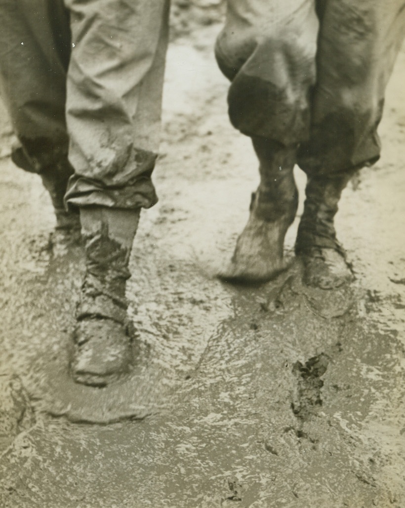 Shine Mister?, 12/2/1943. ITALY -- A pair of American GI boots slog along on "the road to Rome," where a careless step leads to a mud bath. A gooey mess is one way to describe the Fifth Army front near Venafro, and our offensive suffers. Credit (ACME Photo by Bert Brandt, War Pool Correspondent);