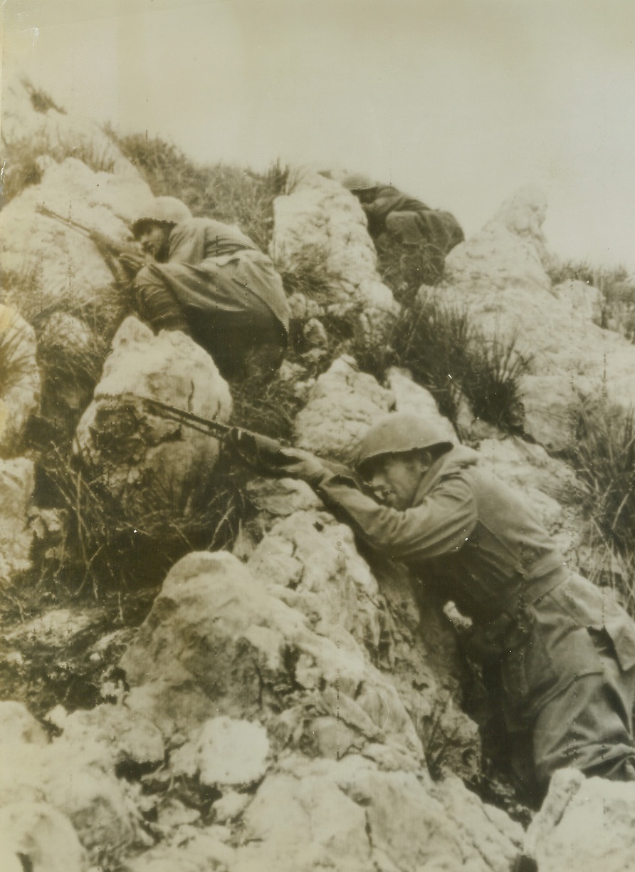 ITALIAN INFANTRYMEN, 12/17/1943. MONT LUNGO, ITALY—Crouching in firing positions behind the rocks that dot Mount Lungo, these Italian infantrymen are battling the Axis, fighting side by side with Americans and Britons of the Fifth Army. Photo radioed to New York today (Dec. 17th) from Algiers. Credit: Acme radiophoto;