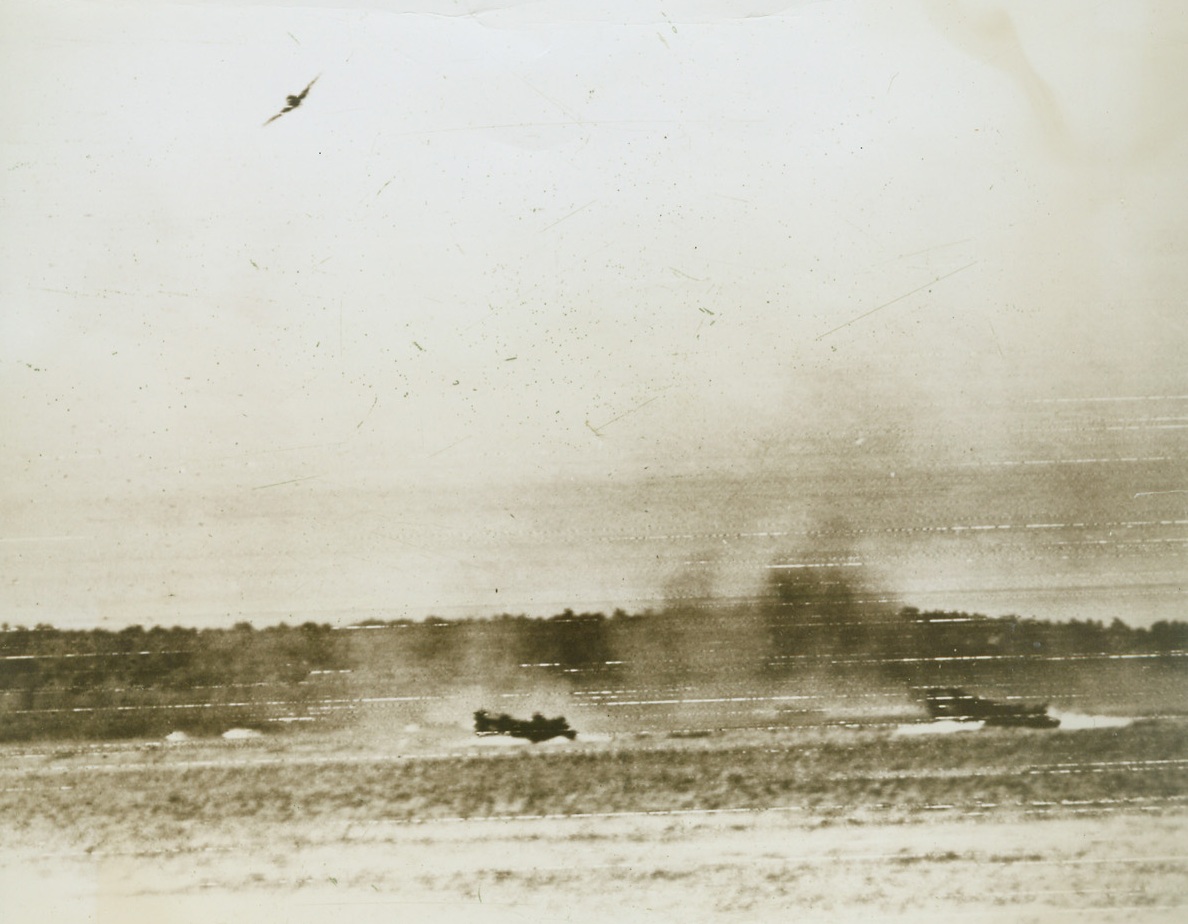 JAP PLANES COULDN’T STOP ‘EM, 12/18/1943. ARAWE, NEW BRITAIN—Winging through New Britain skies, a Jap plane pulls out of its bombing and strafing dive on American invasion craft, heading for the shores of New Britain. The enemy tried, in vain, to halt the advance of our troops, who escaped with the loss of only two LCV’s when they landed at Arawe. Credit: U.S. Signal Corps radiotelephoto from Acme;