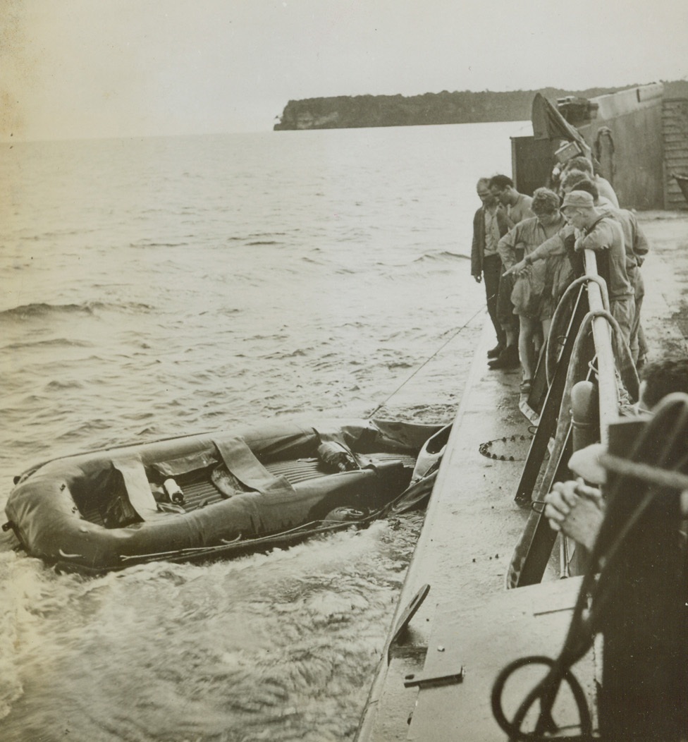 One of Few, 12/31/1943. Arawe, New Britain – One of the few rubber rafts left afloat after the landing at Arawe, New Britain, is pulled in by members of the crew of an LCT. Most of the rafts used in landing operations were sunk by Japanese machine gun fire. Credit: ACME;