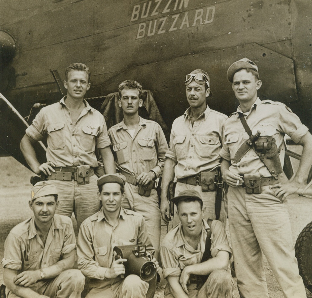 Back from Madang, 12/10/1943. South Pacific – After taking part in an American raid on Madang, New Guinea, in the Bomber “Buzzin Buzzard,” the crew lines up at the nose of their plane. (Top row, left to right): Pilot, Lt. George L. Barnaskey, of Tuckahoe, N.Y.; Co-pilot, Flight Officer Edward V. Stefanowsky, of Superior, Wisc.; Top Gunner Sgt. Harold C. Bridges, of Seattle, Wash.; Navigator-Bombardier Lt. Jack D. Moon, of Lubbock, Texas. (Kneeling, left to right) Radio Operator and Tail Gunner Staff Sgt. Wayland R. Anderson, of Pontiac, Mich.; Myron H. Davies, Life Correspondent, and Waist Gunner Sgt. William T. Strickland, of Richmond, Calif. Credit: ACME;
