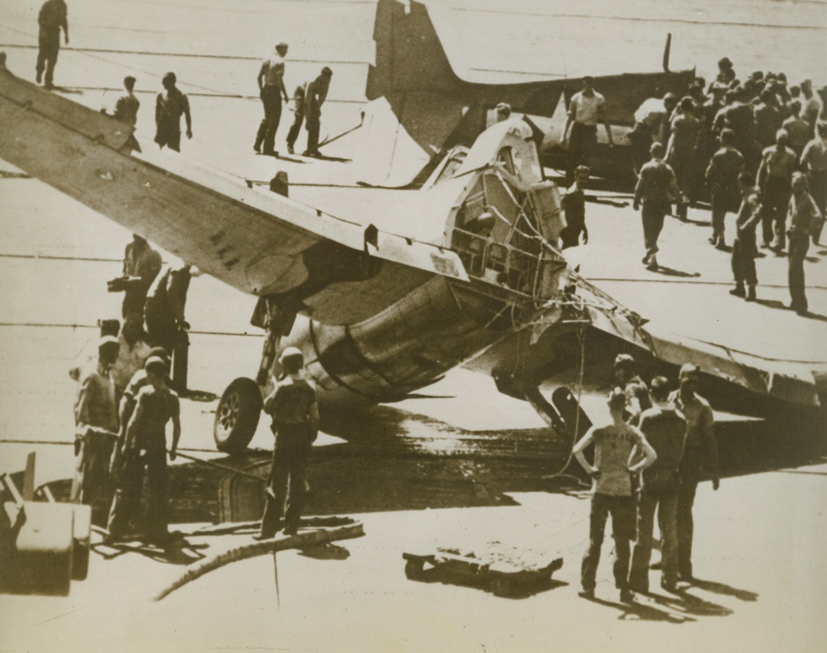 Fighter Plane Breaks in Two, 12/8/1943. Somewhere in the Pacific – Lt. Charles L. Mountenot, of Edgewater, N.J., tried to land his fighter plane on this carrier, with his hydraulic system shot up and with one wheel facing the wrong way. The plane snapped in two when it was caught by the hook. Mountenot had been at Tarawa the day before the Marines landed there. Credit: ACME;