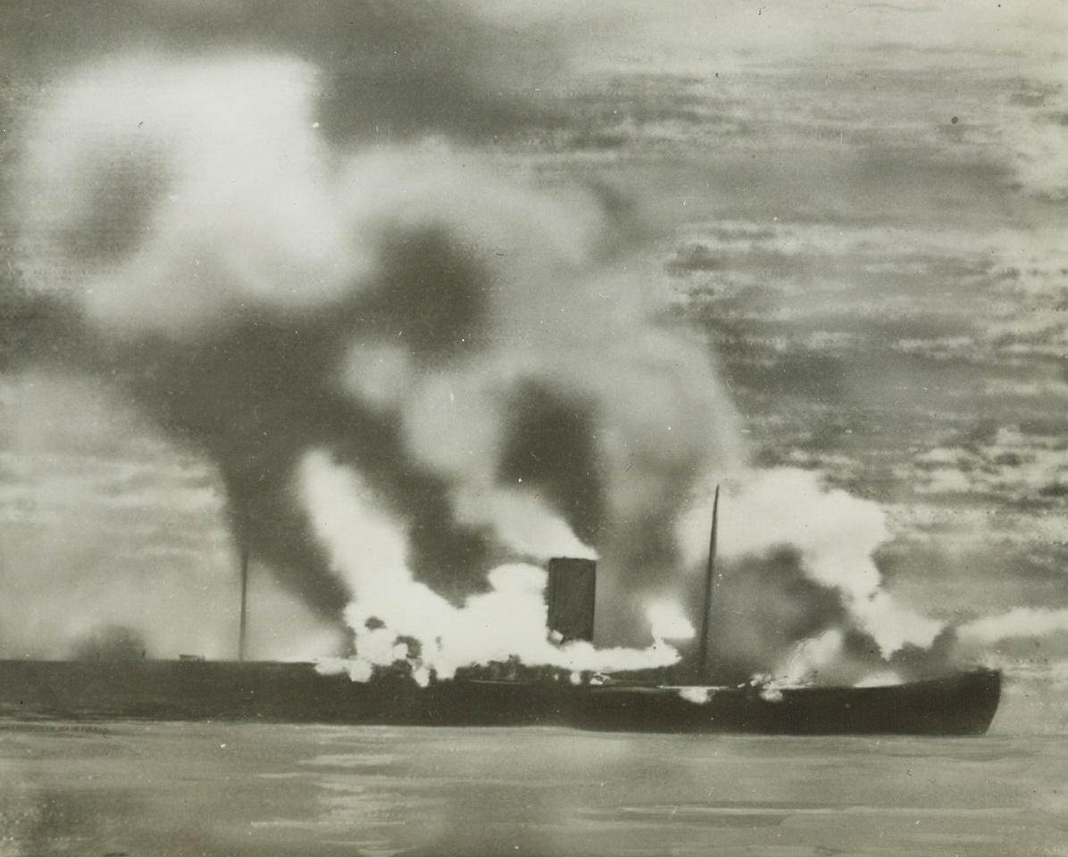 Blockade Runner Ablaze, 12/30/1943. Bay of Biscay – Attacked and sent to the bottom by aircraft of the British Coastal Command, this fast Nazi Blockade Runner was believed to have been nearing the end of its long journey from Japan when it was spotted. British Airmen also sunk three of a force of eleven enemy Destroyers in the battle. Photo radioed to New York from London today (12-30-43). Credit: ACME Radiophoto;